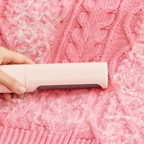 Person using a pink fabric shaver on a pink textured fabric