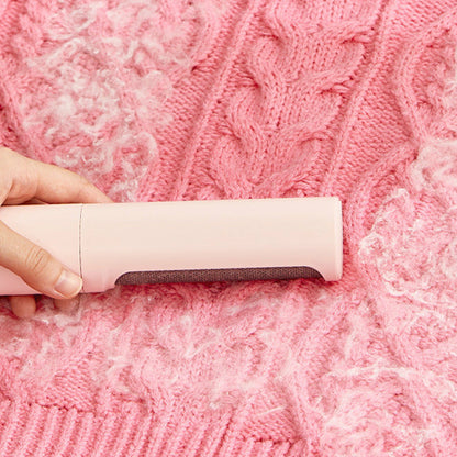 Person using a pink fabric shaver on a pink textured fabric